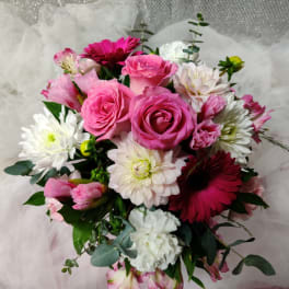 Pink roses and white daisies arranged in a bouquet with tulle wrapping