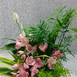 Basket arrangement of pink flowers with white blooms and lush greenery