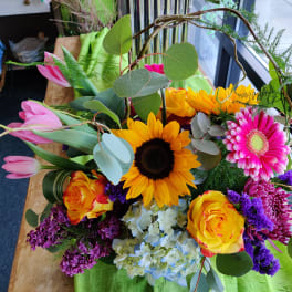 Mixed bouquet with sunflowers, pink tulips, roses, and a gerbera daisy