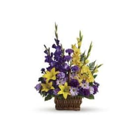 Purple and yellow flowers arranged in a wicker basket