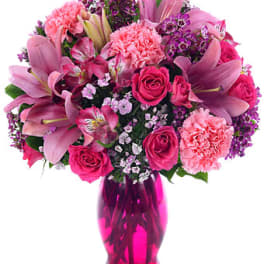 Pink mixed flower bouquet in a magenta vase