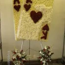 Heart-shaped floral tribute on an easel with two smaller matching sprays below