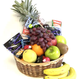 Fruit basket with grapes, apples, oranges, bananas, kiwi, and candy