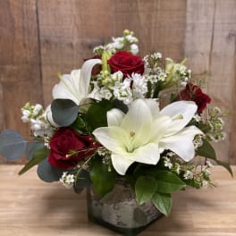 Red roses and white lilies arranged in a square vase
