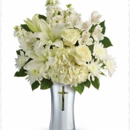 White lilies, roses, and daisies arranged in a silver vase