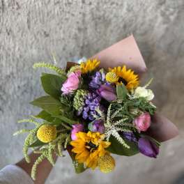 Hand-tied bouquet with sunflowers, purple and pink blooms