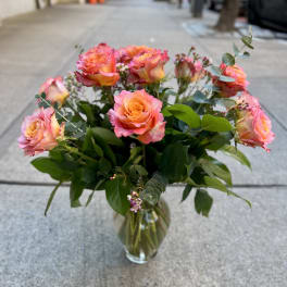 Pink and orange roses in a clear glass vase