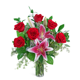 Red roses and pink lilies in a clear glass vase