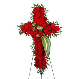 Red rose cross on a stand with green foliage