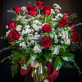 Bouquet of red roses and white filler flowers in a glass vase