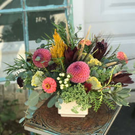 Mixed bouquet in a white square vase with pink and coral blooms