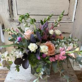 Mixed bouquet in a glass vase with pink, peach, and white flowers