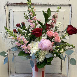 Mixed bouquet of pink and red roses in a striped vase