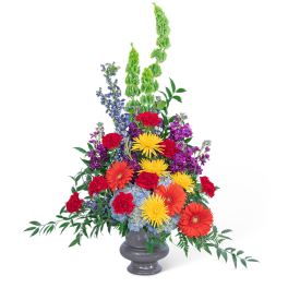 Tall mixed flower arrangement in a gray vase with bright red, orange, yellow, purple, and blue blooms