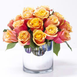 Bouquet of orange and pink roses in a clear glass vase