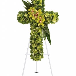 Green floral cross on a white easel with yellow orchids