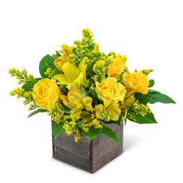 Yellow roses and lilies in a wooden cube container
