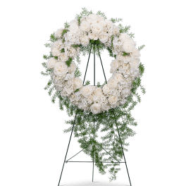 White rose and hydrangea funeral wreath on a stand