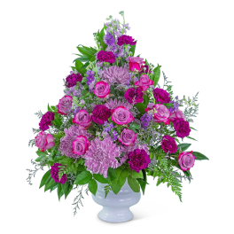 Pink and purple floral arrangement in a white vase