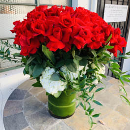 Large bouquet of red roses with white hydrangeas in a green vase