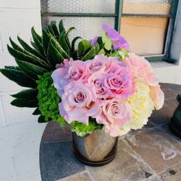 Pink roses and hydrangeas arranged in a black vase