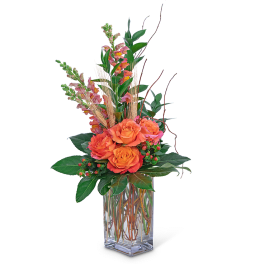 Orange roses in a clear glass vase with tall pink snapdragons