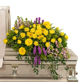 Yellow and purple floral spray on a silver casket