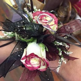Wrist corsage with pink-and-white roses and black ribbon