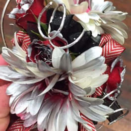 Small bouquet of white daisies and red roses with striped ribbon accents