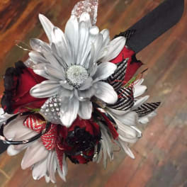 Red and white floral wrist corsage with a black ribbon band