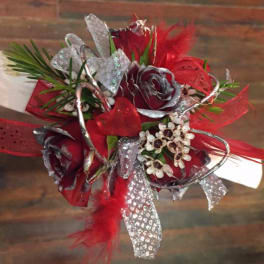 Red and silver floral corsage with ribbon and feathers