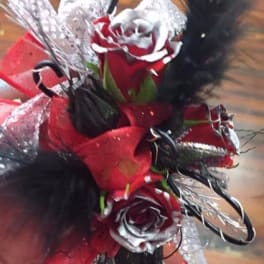 Small red and white rose corsage with black feathers and ribbon