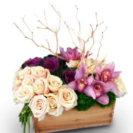 Mixed roses and pink orchids arranged in a wooden box