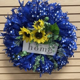 Blue polka-dot wreath with sunflowers and a "this is home" sign