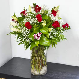 Red roses and white lilies in a clear glass vase