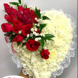 Heart-shaped bouquet of red roses and white carnations with lace trim