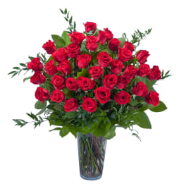 Tall bouquet of red roses in a clear glass vase