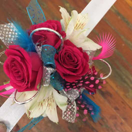 Handheld bouquet of hot pink roses and white lilies with colorful decorative feathers