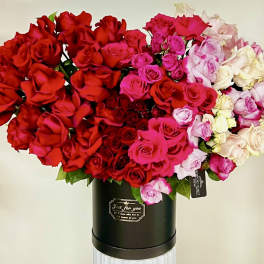 Large bouquet of red, pink, and white roses in a black hatbox