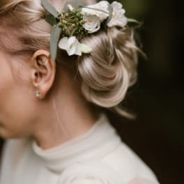 Woman wearing a white floral hairpiece in her blonde updo