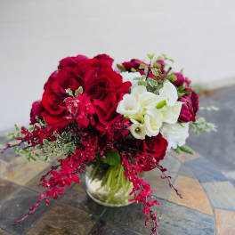 Red roses and white calla lilies in a glass vase