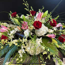Large floral arrangement with red roses, pink lilies, and white blooms