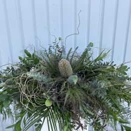Large greenery arrangement with a central cream protea-like bloom
