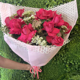 Bouquet of hot pink roses wrapped in pale pink paper