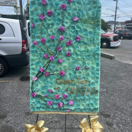 Large floral display with turquoise flowers and pink blossoms on a stand