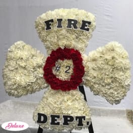 White floral standing display shaped like a fire department emblem with red center