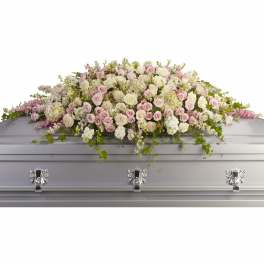 Pastel rose and white floral spray on a silver casket