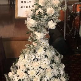 Tall white floral arrangement with a Holy Bible centerpiece