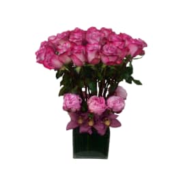 Pink roses and purple flowers arranged in a dark glass vase