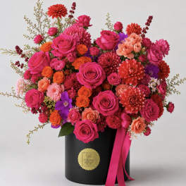 Bright mixed bouquet in a black hatbox with a pink ribbon